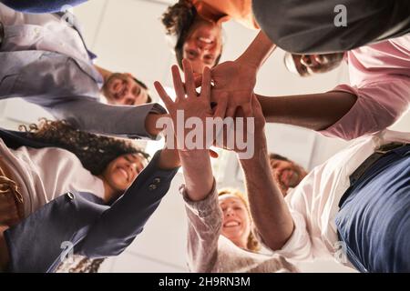 Group of friends as a startup team stacking hands for team spirit and network Stock Photo
