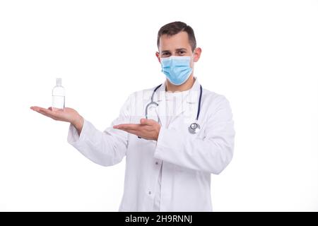 Man Doctor Holding Hands Sanitizer Pointing at It Wearing Medical Mask. Medicine, Virus, Doctor Concept Stock Photo