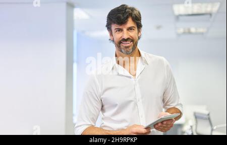 Successful businessman as a manager or consultant using smartphone in the office Stock Photo