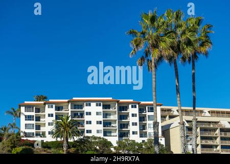 San Clemente, CA, USA – November 13, 2021: Apartment building with balconies and large palm trees in the beach community of San Clemente, California. Stock Photo