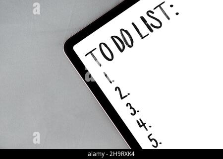 Digital tablet with to do list on gray fabric, textile background with copy space Stock Photo