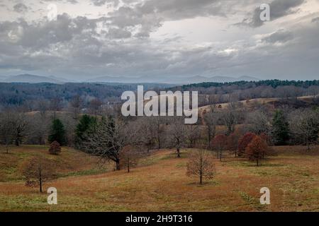 A wide angle painterly photo of rolling hills under threatening skies with the Blue Ridge Mountains in the background. Stock Photo