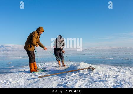 Ardahan, Turkey - January 18, 2020 : Fishermen catches fishes on Lake Cildir which is frozen every winter.The Lake is located on Eastern Anatolia. Stock Photo