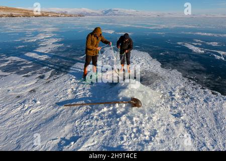 Ardahan, Turkey - January 18, 2020 : Fishermen catches fishes on Lake Cildir which is frozen every winter.The Lake is located on Eastern Anatolia. Stock Photo