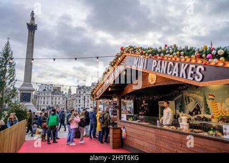 Trafalgar Square, London, UK. 8 December 2021. Christmas market stalls outside the National Gallery Portico draw people for food, drink and gift shopping on a grey and cold London day. Credit: Malcolm Park/Alamy Live News. Stock Photo