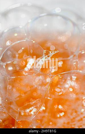 Abstract orange texture of soap bubbles close-up. Vertical crop. Stock Photo