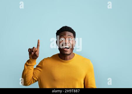 Excited african american guy pointing finger up Stock Photo