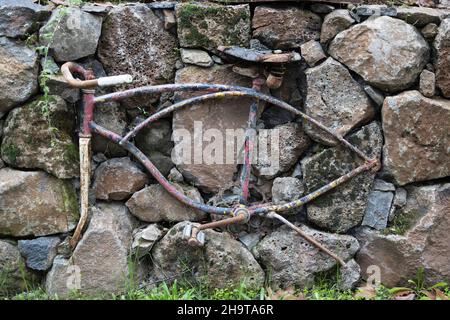 An old bicycle frame imbedded in a stone wall. Stock Photo