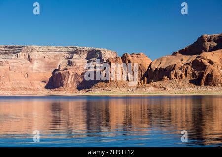 Glen Canyon National Recreation Area, Utah, USA. High red sandstone cliffs reflected in the tranquil waters of Lake Powell. Stock Photo