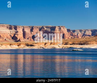 Glen Canyon National Recreation Area, Utah, USA. High red sandstone cliffs reflected in the tranquil waters of Lake Powell. Stock Photo