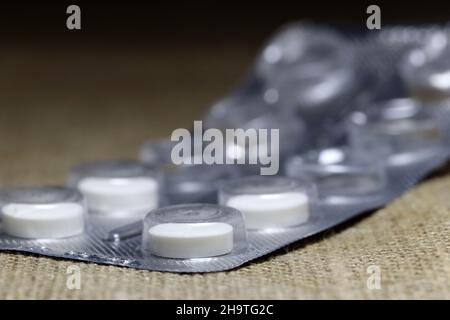 Pills in blister on blurred  background. Closeup. Stock Photo