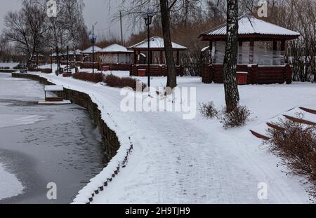 empty wooden pergola standing in a row in winter park Stock Photo