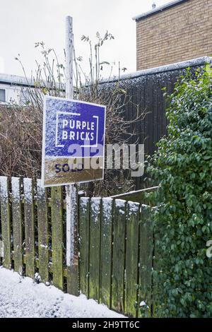 Purple bricks on-line estate agent sold sign with snow. Stock Photo