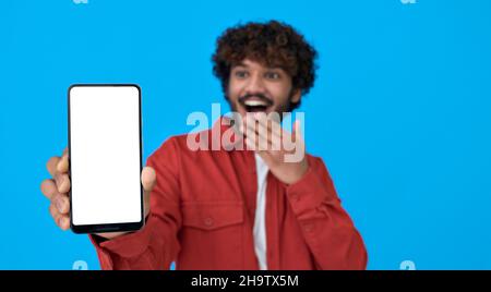 Excited young indian man holding phone showing big white mockup screen. Stock Photo