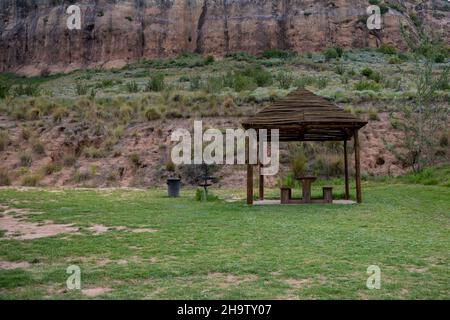 Picnic spot in mountains with wooden benches and a wooden roof for sun protection. Stock Photo