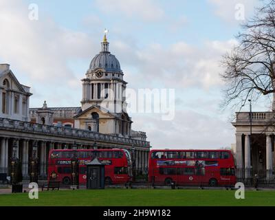 London, Greater London, England, December 04 2021: Two red buses outside Greenwich University as seen from Greenwich Park. Stock Photo