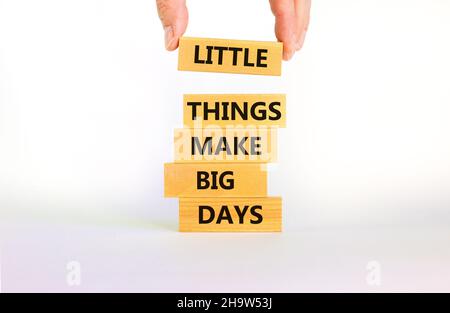 Little things make big days symbol. Wooden blocks with words Little things make big days. Beautiful white background, copy space. Businessman hand. Bu Stock Photo