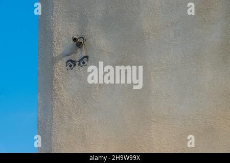 A pair of eyes spray painted using a stencil on a concrete building wall in Santa Barbara, California. Stock Photo