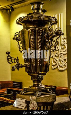 Tehran,Iran,Dezember 02,2021:A huge copper samovar coated with stainless steel dusting with beautiful forged handles and leaf decor on a beautiful sta Stock Photo