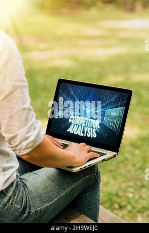Handwriting text Competitor Analysis. Conceptual photo Determine the Strength Weakness of Competitive Market Woman Typing On Laptop Sitting Outside Stock Photo
