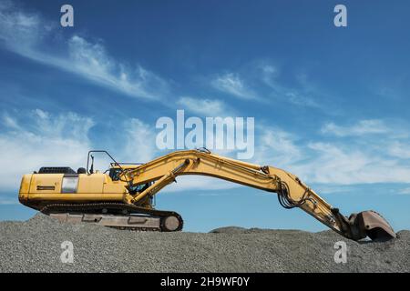 Excavator on gravel and stones Stock Photo