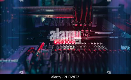 Ai SMT New Neural Generation Computer Chips Concept: Production of high-tech computer boards on an automatic SMT machine. Digital technologies for automation of industry. Red neon lights on Chip board Stock Photo