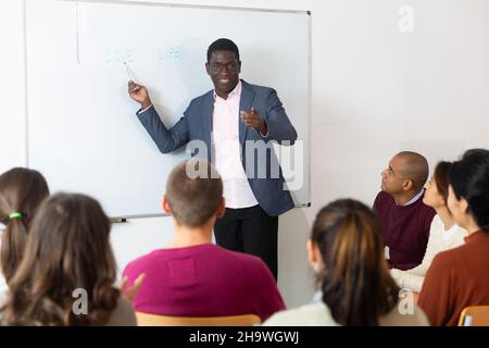 African american male teacher lecturing to adult students at auditorium ...