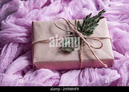 kraft paper gift box next to a vintage tablecloth hand-painted  pink gauze. Boho style gauze runners, rustic tablecloth for wedding decor Stock Photo