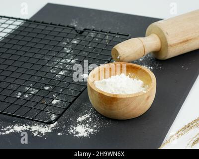 Empty metal grill, rolling pin, scattered flour in a wooden bowl Stock Photo