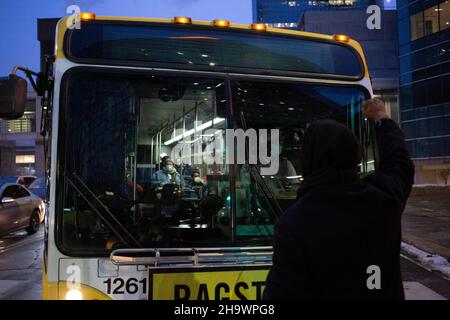 Minneapolis, Minnesota, USA. 8th Dec, 2021. December 8, 2021-Minneapolis, Minnesota, USA: A demonstrator blocks a Metro Transit bus while holding up their fist. Demonstrators march outside of Hennepin County Government Center as day 1 of KIMBERLY POTTER's trial wraps up. Potter, 49, of Champlin, Minnesota, is being tried for manslaughter in the killing of DAUNTE WRIGHT, 20, of Brooklyn Center, Minnesota, on April 11, 2021. (Credit Image: © Henry Pan/ZUMA Press Wire) Credit: ZUMA Press, Inc./Alamy Live News Stock Photo