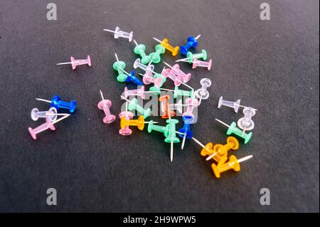 Notice Board Pin placed on a table isolated on black background. High angle view. Stock Photo