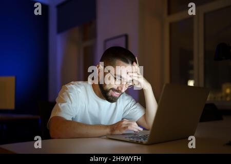 Happy specialist work overtime look on laptop monitor successful find problem solution after failure Stock Photo