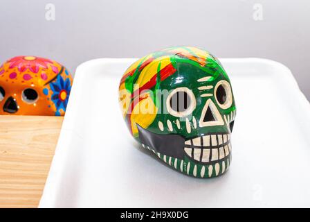 Green Painted human skull with flowers for Mexico's Day of the Dead on color background, selected focus. Stock Photo