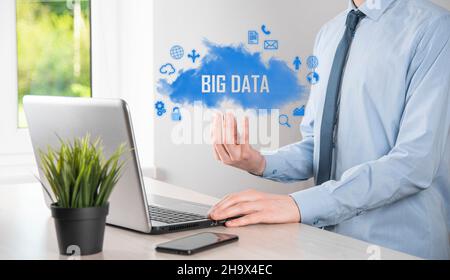Businessman holds the inscription , word BIG DATA. Padlock , brain ,man, planet,graph, magnifier, gears, cloud, grid, document, letter, phone icon Stock Photo