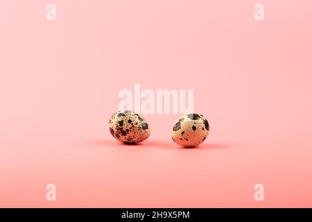 two quail eggs on a pink background Stock Photo