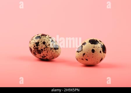 two quail eggs on a pink background Stock Photo