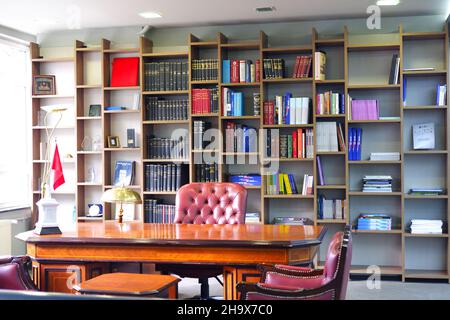 Vintage Boss Desk and Leather Chair with Bookshelf at the Background Stock Photo