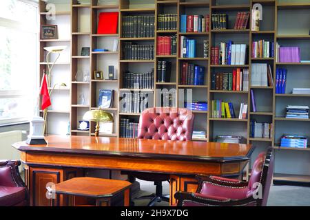 Vintage Boss Desk and Leather Chair with Bookshelf at the Background Stock Photo