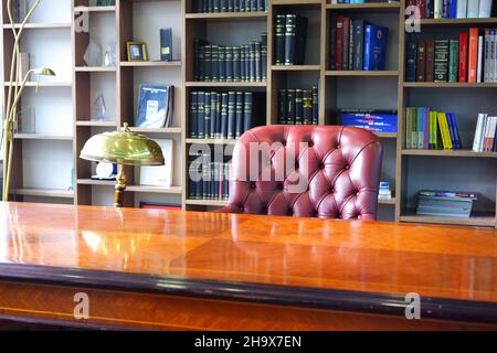 Vintage Boss Desk and Leather Chair with Bookshelf at the Background Stock Photo