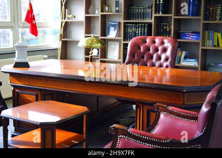 Vintage Boss Desk and Leather Chair with Bookshelf at the Background Stock Photo