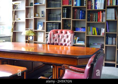 Vintage Boss Desk and Leather Chair with Bookshelf at the Background Stock Photo