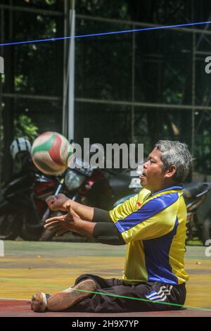 athletes with disabilities practice sitting volleyball on the indoor ...