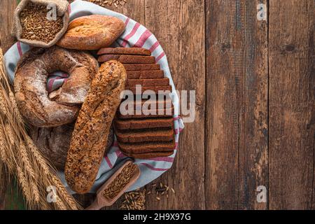 Fresh, crispy bread of various kinds on a wooden table. Bakery products. Stock Photo