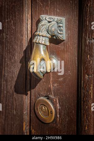 Antique hand shaped door knocker closeup Stock Photo