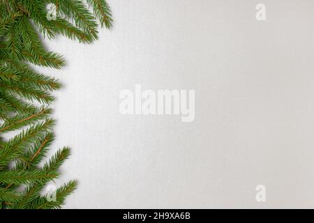 Fir branches frame on a silver colored background. Festive composition. Stock Photo