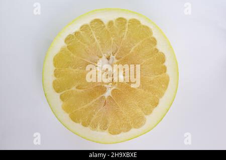 Pamelo fruit cut in half close up on white clipping background in middle of frame Stock Photo
