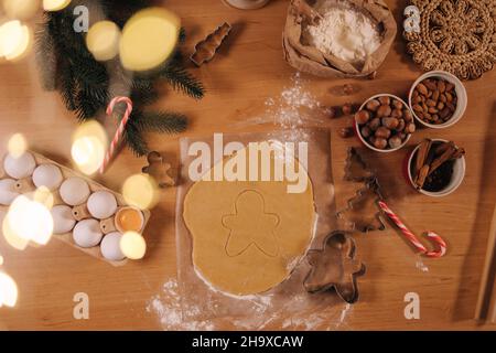 Top view of raw dough for cooking Christmas cookies ginger men on wooden table. Preparing for baking Stock Photo
