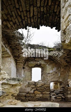 Ruins of an ancient Christian temple. Collapsed ceiling. Masonry, rooms with arched vaults. Tree grow on the wall. Moldova. Selective focus. Stock Photo