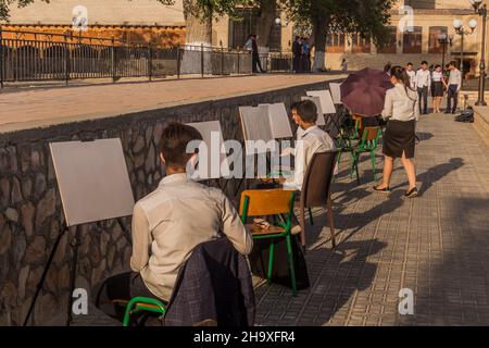 BUKHARA, UZBEKISTAN - APRIL 30, 2018: Painting students in the center of Bukhara, Uzbekistan Stock Photo