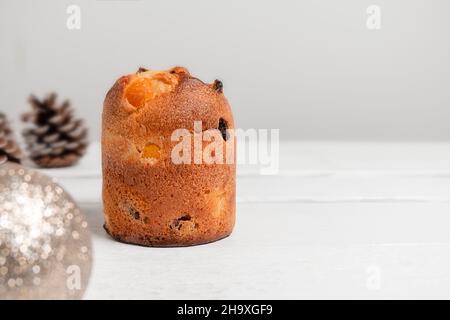 Panettone with raisins and Christmas decorations on white wooden table. Traditional Italian Christmas dessert Stock Photo